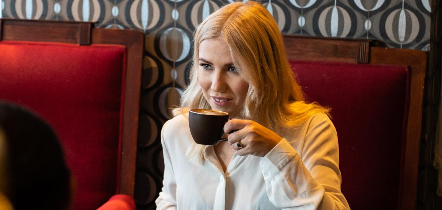 Dame hygger seg med kaffe på en kafé i Tromsø